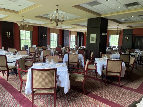 View of the Charter Rooms upholstered armchairs situated around linen draped tables