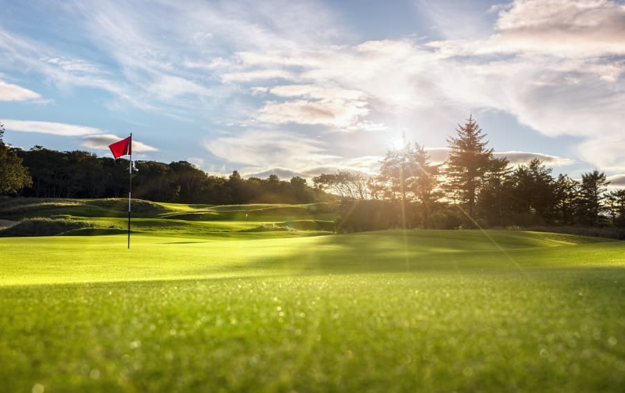 Golf Course Putting Green With Flag At Sunrise