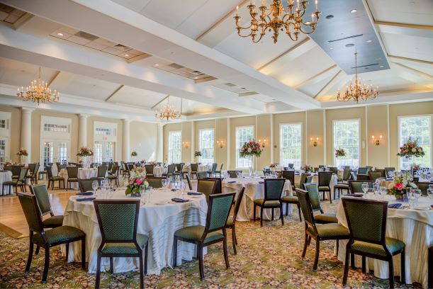View of spacious Grand Ballroom decorated for an event with flower centerpieces and linen tablecloths